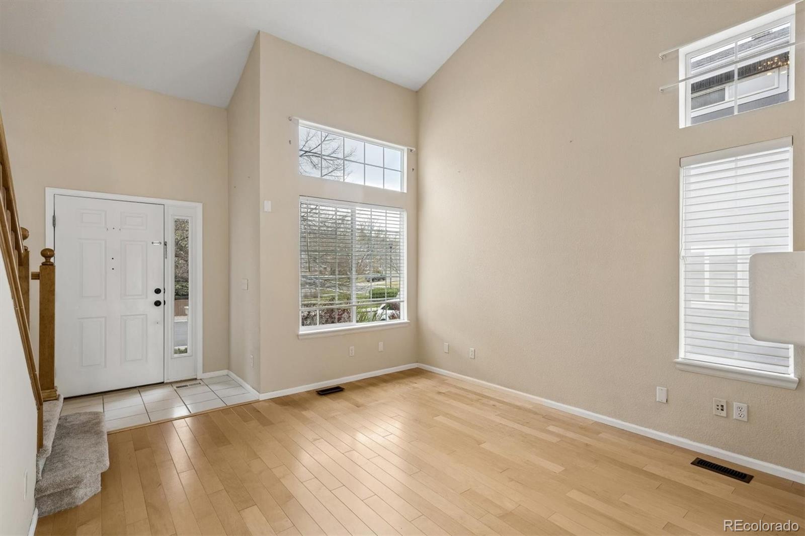 557 West Stellars Jay Drive Highlands Ranch, CO 80129 - Photo 5 of 41 an empty room with wooden floor and windows