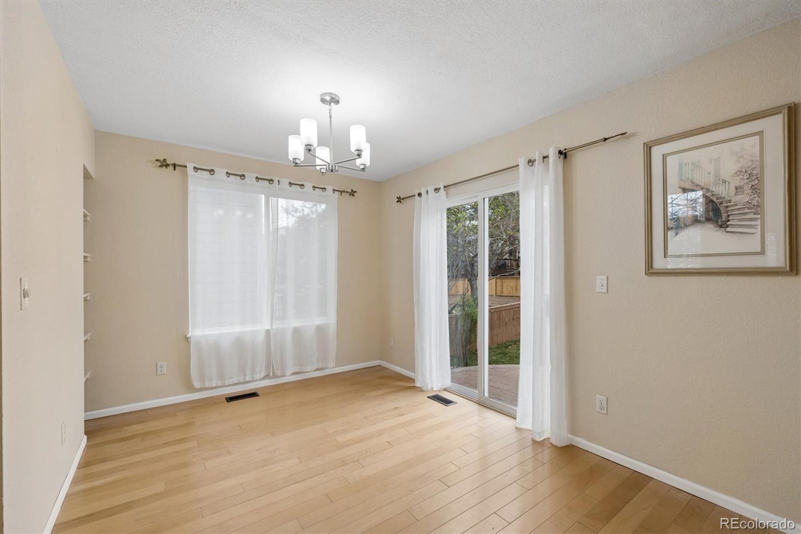 557 West Stellars Jay Drive Highlands Ranch, CO 80129 - Photo 9 of 41 wooden floor in an empty room with a window
