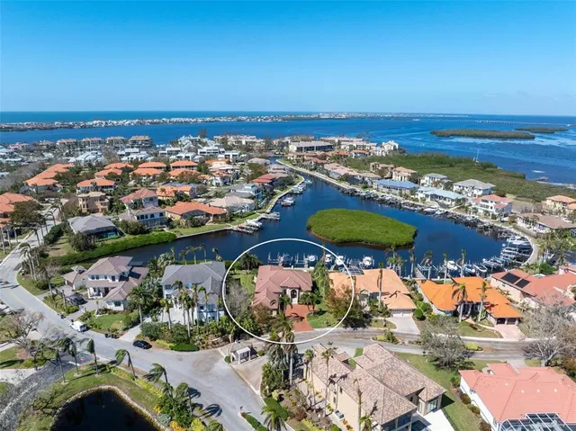 an aerial view of a city with lots of residential buildings and ocean view in back