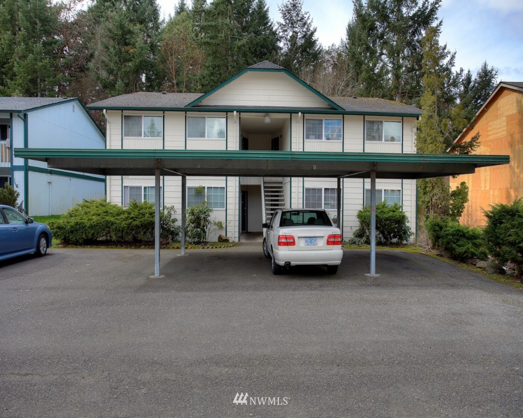 3919 Mason Loop Road Tacoma, WA 98409 - Photo 1 of 20 a car parked in front of a house with a yard