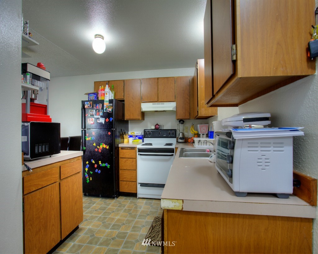 3919 Mason Loop Road Tacoma, WA 98409 - Photo 6 of 20 a kitchen with a sink dishwasher stove and refrigerator