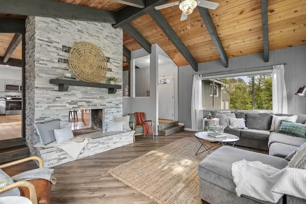 a kitchen with stainless steel appliances kitchen island granite countertop a stove a refrigerator a dining table and chairs with wooden floor