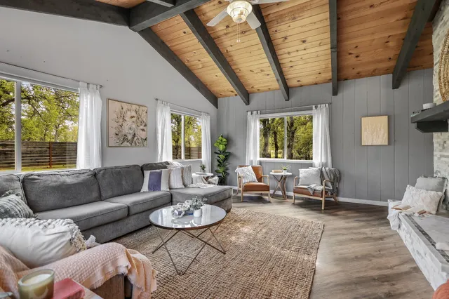 a spacious bedroom with a bed a wall painting on wall and a lamp