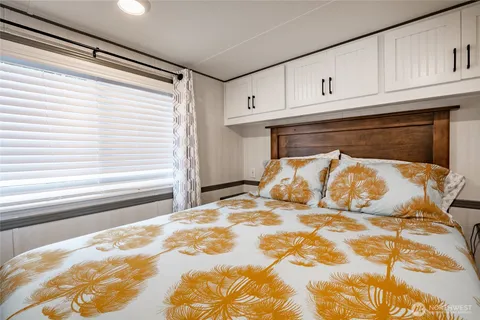 a bed sitting in a kitchen next to a window