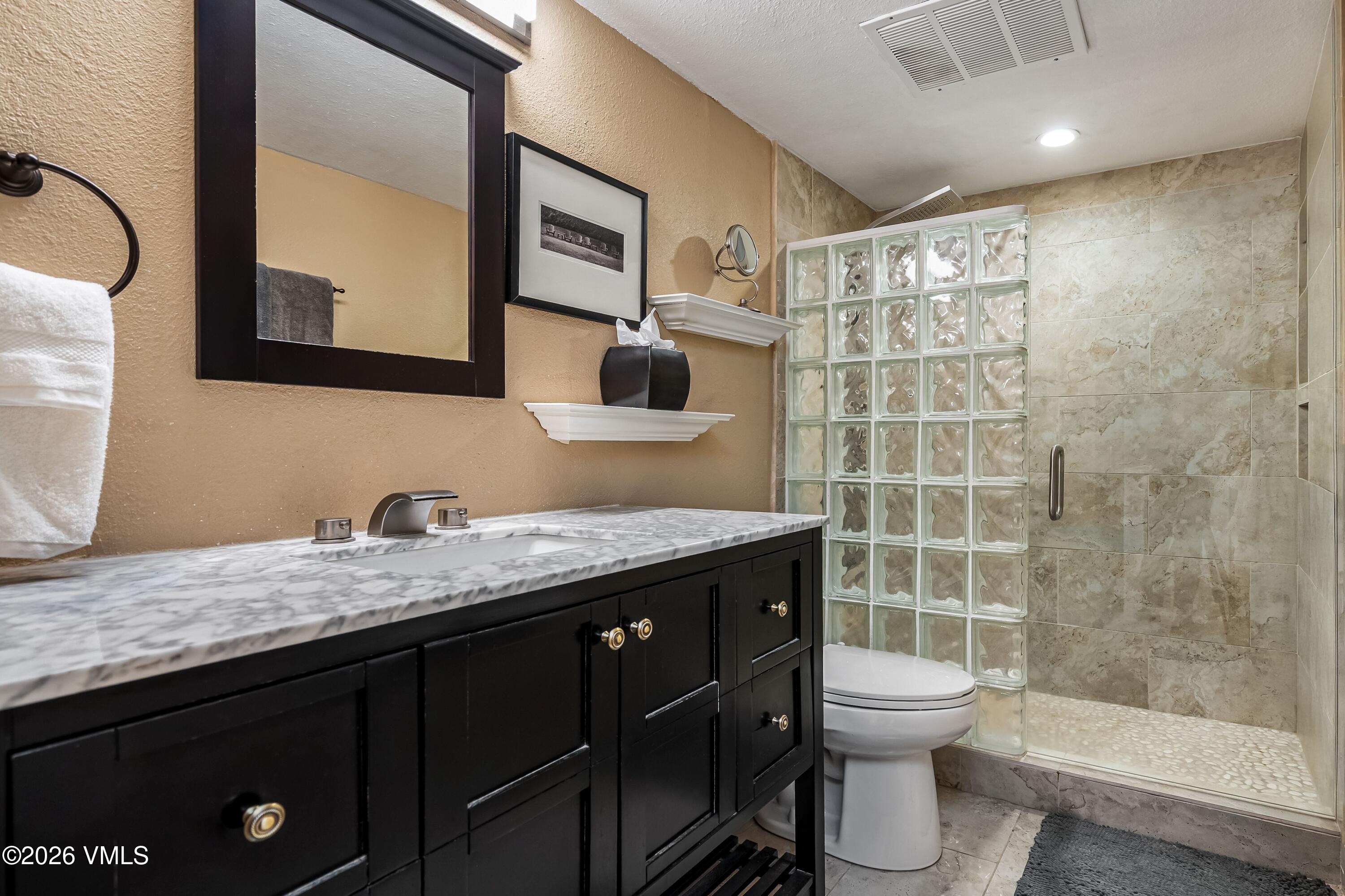 500 South Frontage Road East, Unit 308 Vail, CO 81657 - Photo 11 of 25 a bathroom with a granite countertop sink toilet and shower