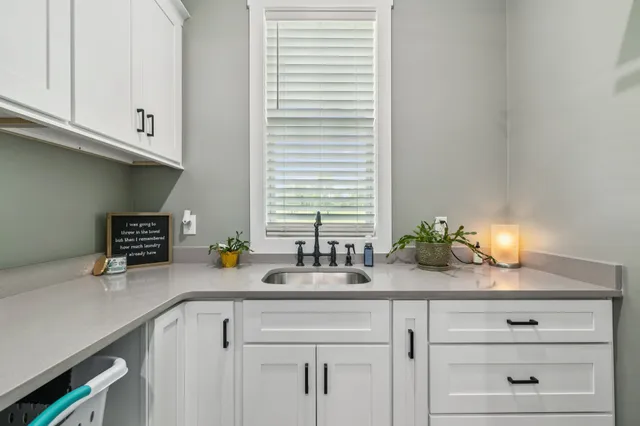 a front view of a house with a garden and lake view