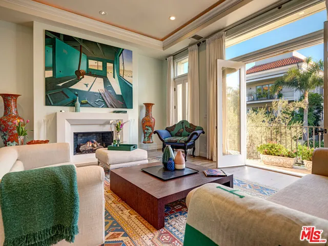 a living room with furniture a fireplace and a large window