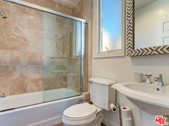 a kitchen with stainless steel appliances granite countertop a refrigerator a sink and wooden floors