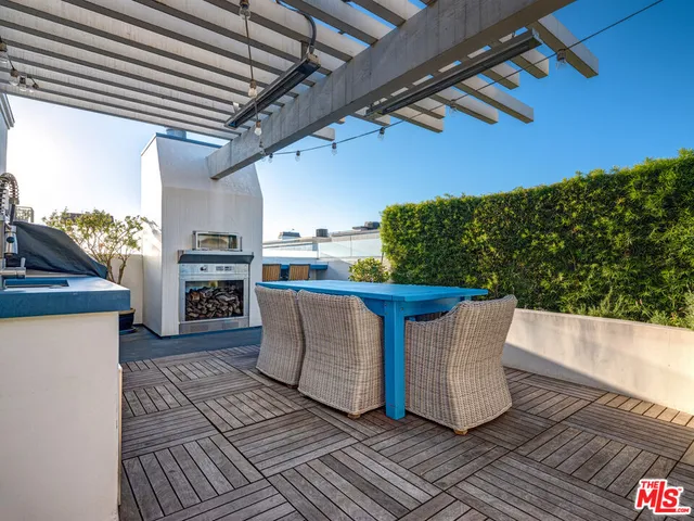 a view of a patio with table and chairs with wooden floor and fence