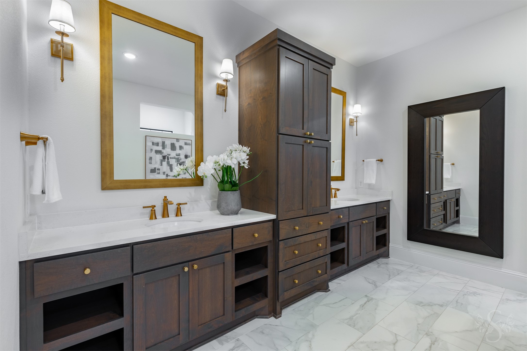 27919 Indigo Ridge Drive Fulshear, TX 77441 - Photo 27 of 50 Elegant dual vanities with rich cabinetry, quartz countertops, gold hardware, and framed mirrors provide a sophisticated and highly functional dressing space. Sconce lighting and abundant storage complete this luxurious owner’s retreat.