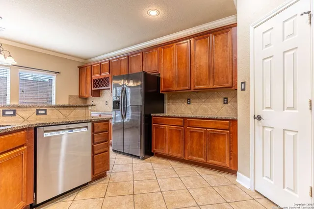 a kitchen with stainless steel appliances granite countertop a refrigerator sink and cabinets