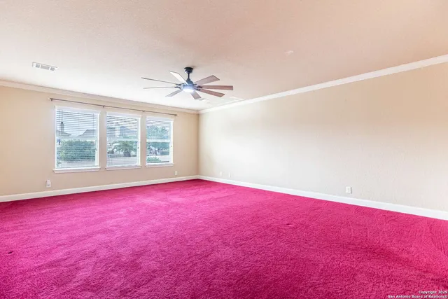 an empty room with windows and fan