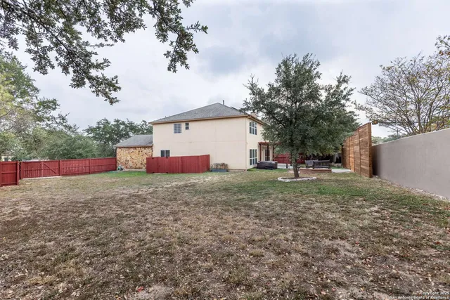 a view of a house with wooden fence and yard