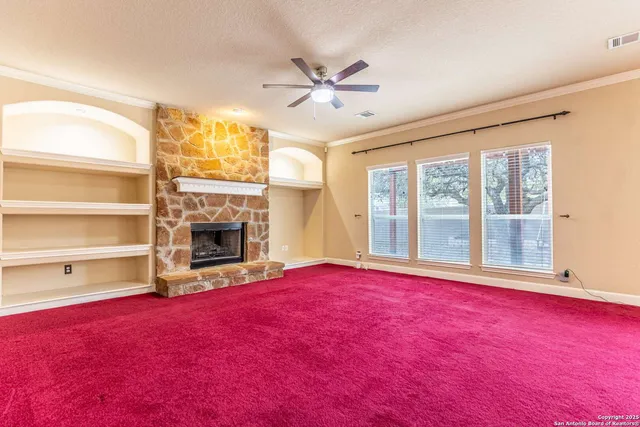 a view of an empty room with a fireplace and a window