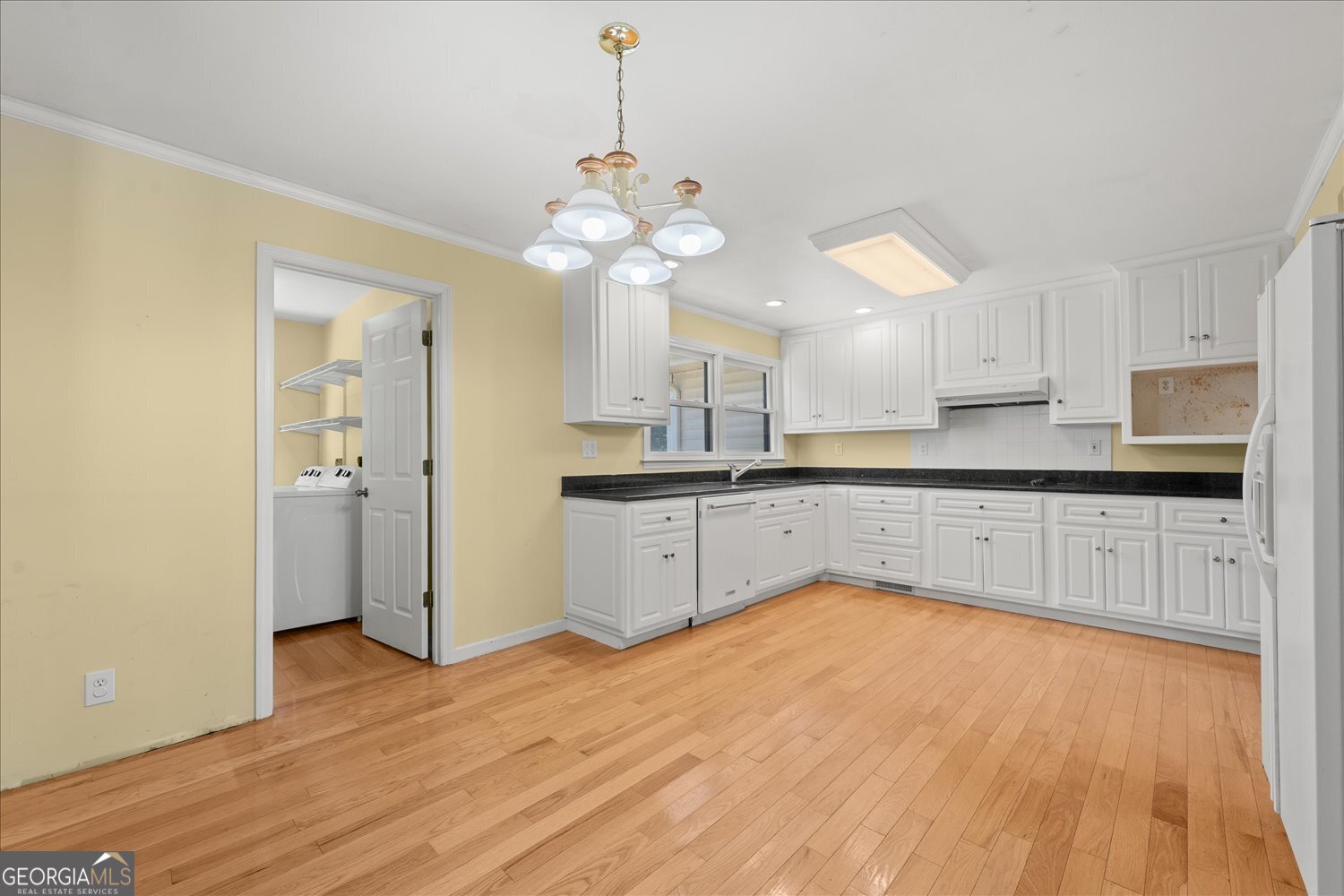 110 Riverside Drive Washington, GA 30673 - Photo 7 of 29 a large kitchen with granite countertop a stove a sink and white cabinets with wooden floor