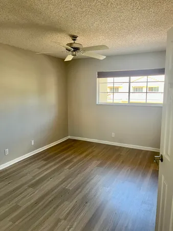 a view of a room with wooden floor and a ceiling fan