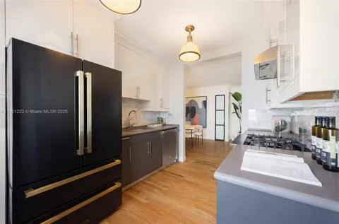 a kitchen with stainless steel appliances granite countertop a refrigerator a stove and a sink