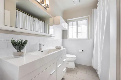 a bathroom with a sink toilet and a window