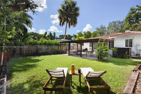 a view of a chair and table in backyard of the house