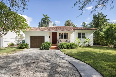 a front view of a house with a yard and potted plants