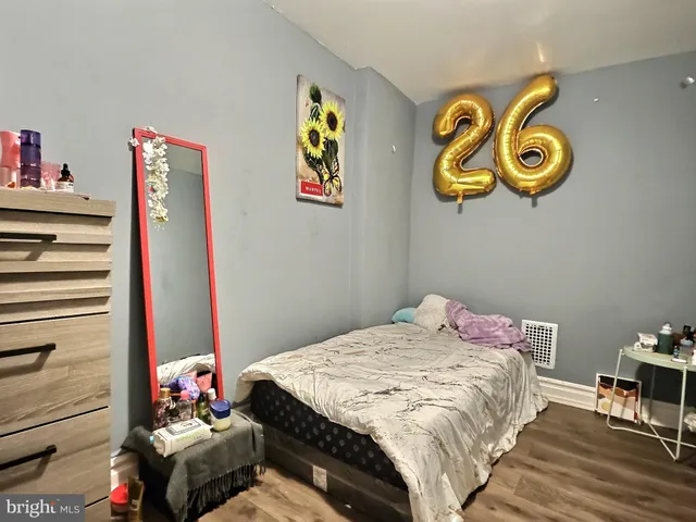 a bedroom with a bed and painting on the wall