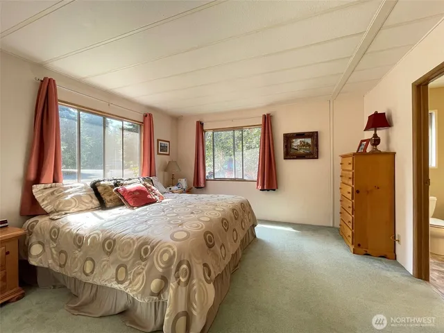 a bed sitting in a bedroom next to a window