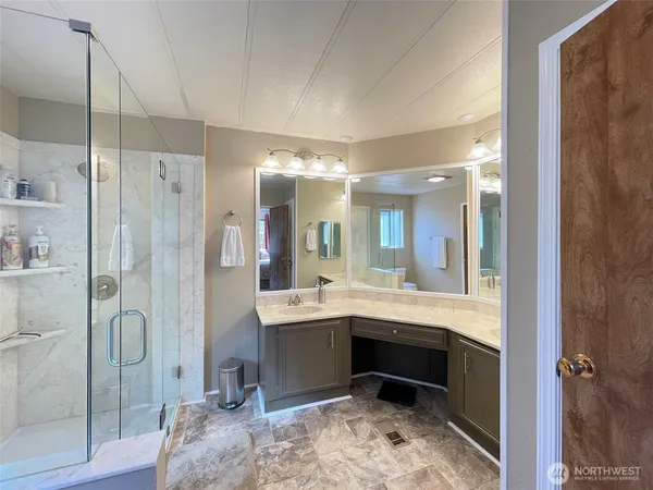 a bathroom with a double vanity sink mirror and shower