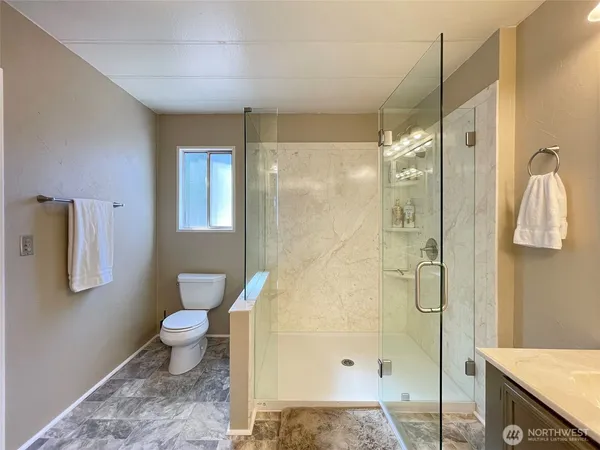 a bathroom with a granite countertop sink toilet and shower