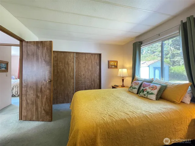 a bedroom with a bed and a large window