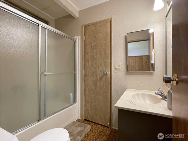 a bathroom with a sink and mirror with toilet