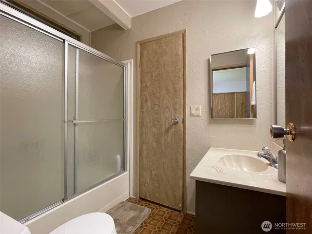 a bathroom with a sink and mirror with toilet