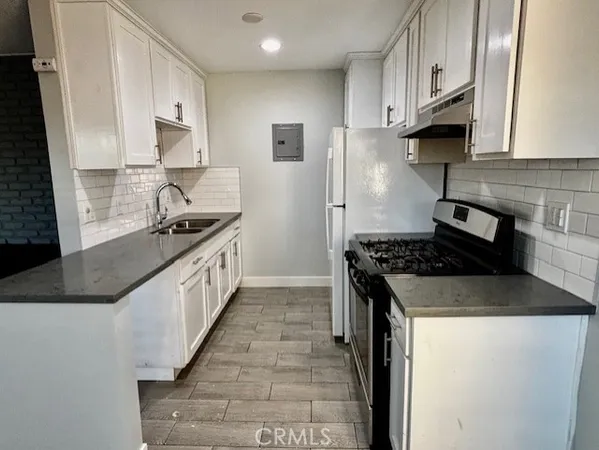 a kitchen with stainless steel appliances granite countertop a stove a sink and a refrigerator