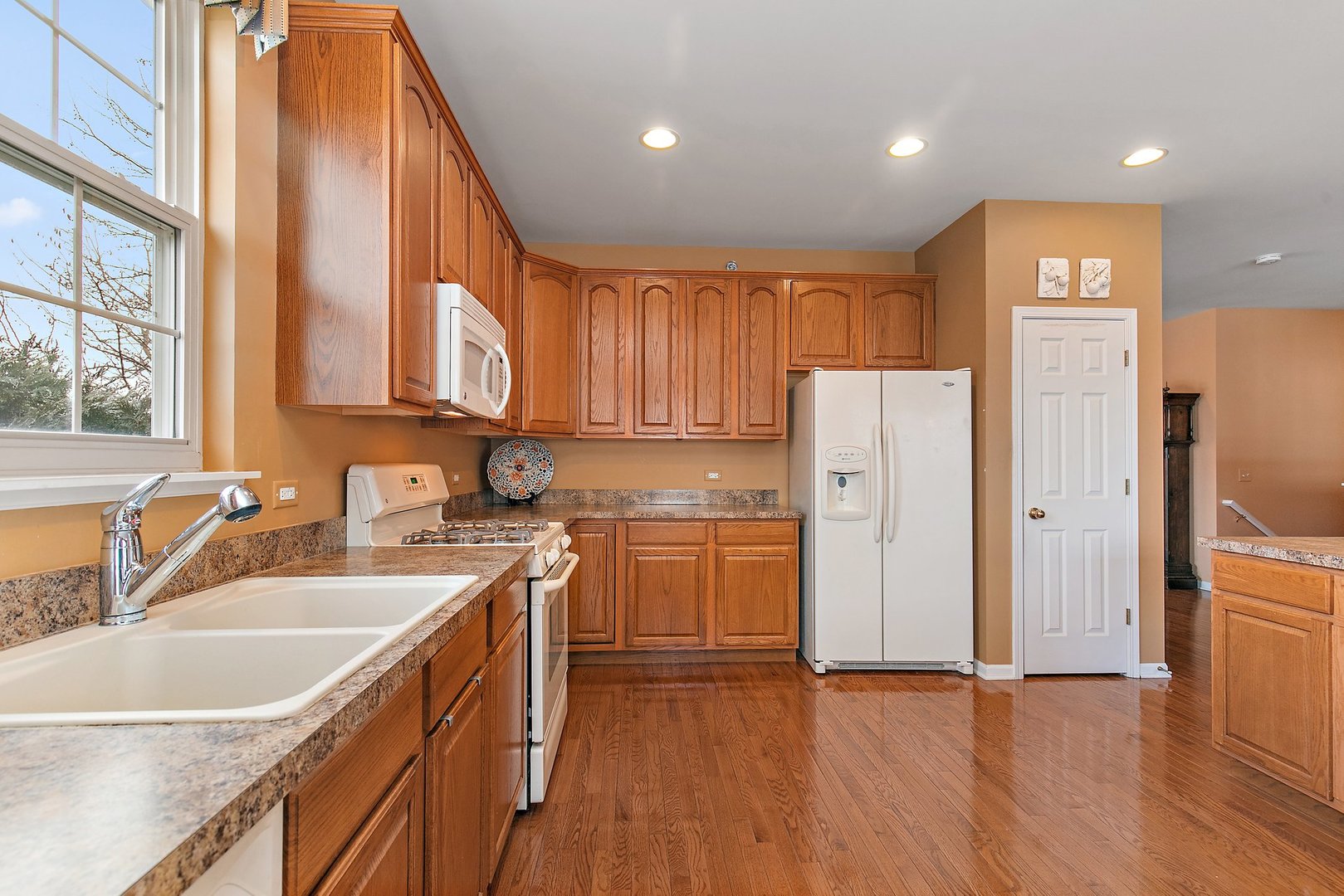 5876 Leeds Road Hoffman Estates, IL 60192 - Photo 11 of 37 a kitchen with a sink a refrigerator and cabinets