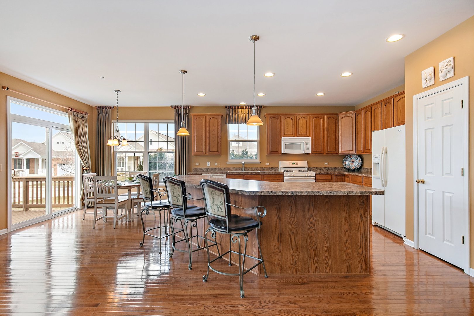 5876 Leeds Road Hoffman Estates, IL 60192 - Photo 10 of 37 a open kitchen with stainless steel appliances granite countertop a stove top oven a dining table and chairs with wooden floor