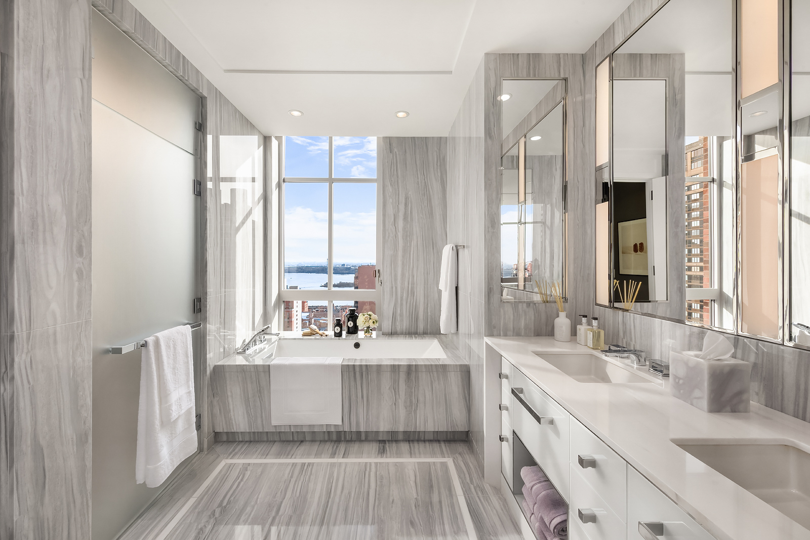 200 East 95th Street, Unit 15A Manhattan, NY 10128 - Photo 9 of 25 a bathroom with a double vanity sink a mirror and a bathtub