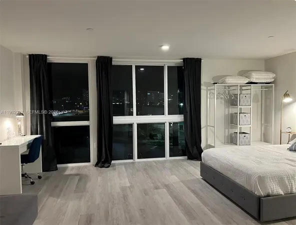a bedroom with a bed and a large window