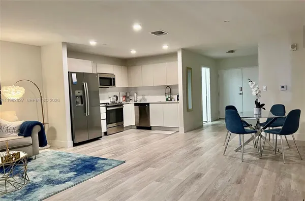 a view of kitchen with refrigerator dining table and chairs