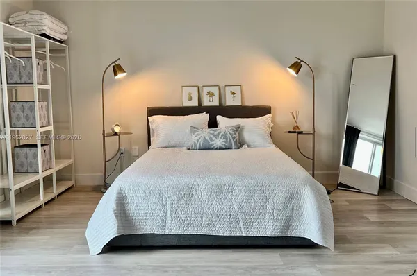 a bedroom with a bed and a mirror on dresser