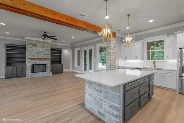 an open kitchen with a sink and dishwasher a fireplace with wooden floor