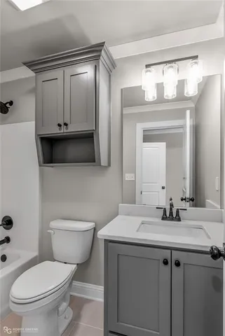 a bathroom with a toilet a sink a mirror and vanity