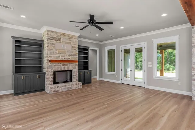 a view of an empty room with a window and fireplace