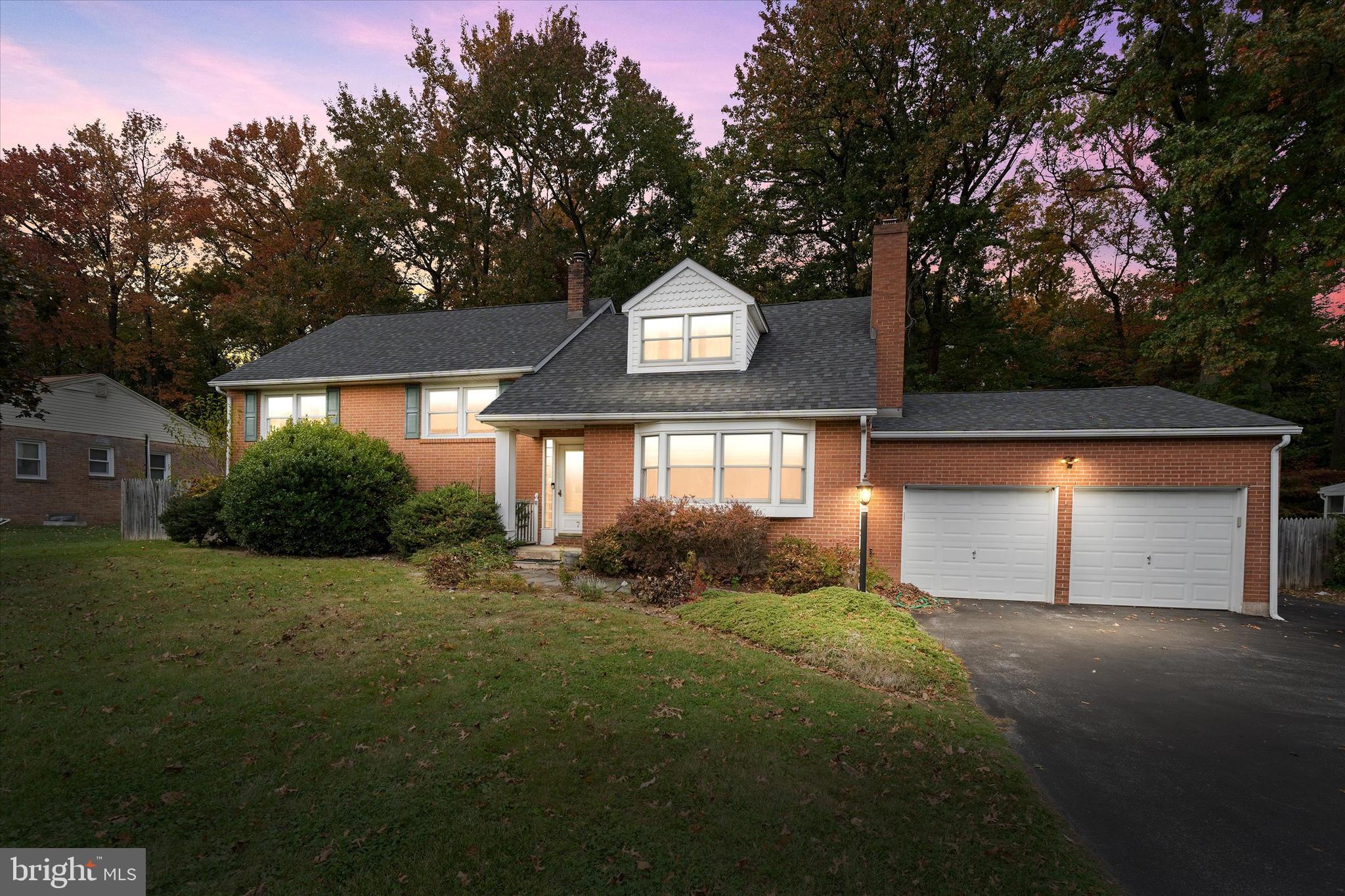 a front view of a house with yard and green space