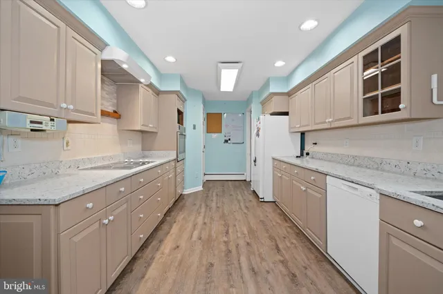 a large kitchen with stainless steel appliances granite countertop a lot of counter space and wooden floors