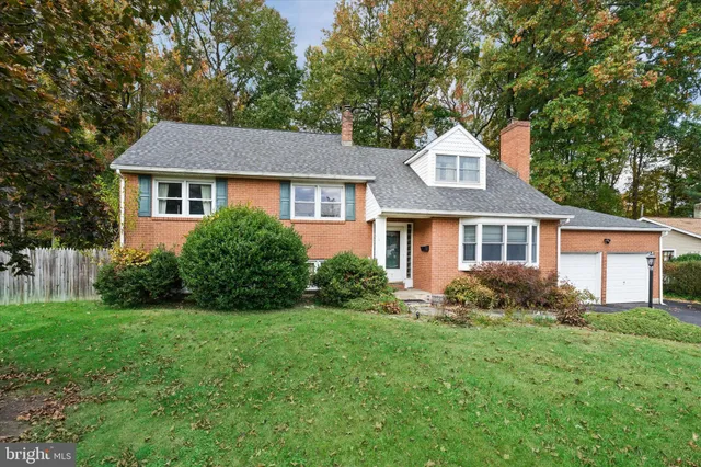 a front view of a house with a yard and trees