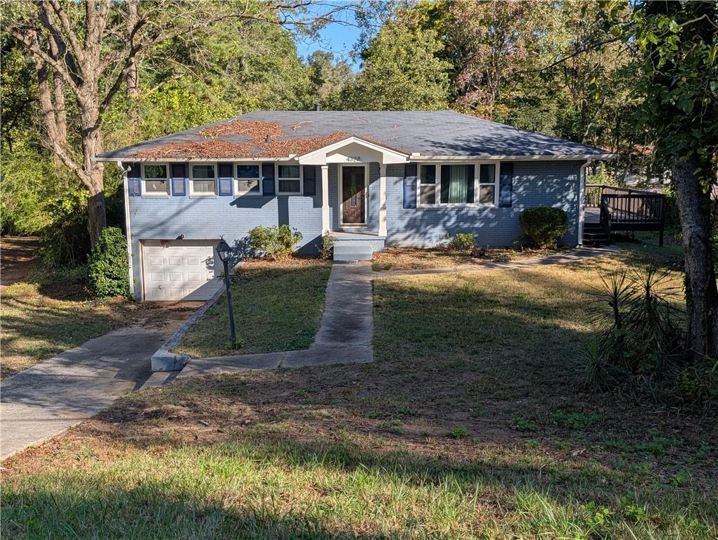 4328 Rockbridge Road Southwest Stone Mountain, GA 30083 - Photo 2 of 16 a front view of a house with garden