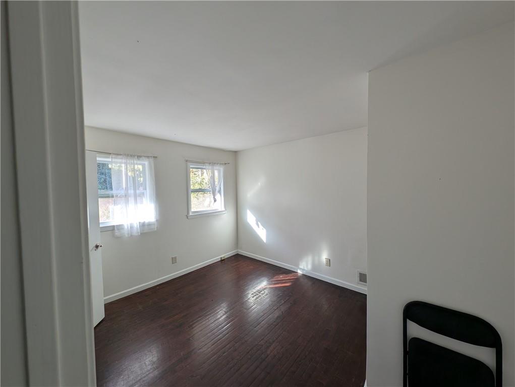 4328 Rockbridge Road Southwest Stone Mountain, GA 30083 - Photo 7 of 16 an empty room with wooden floor and windows