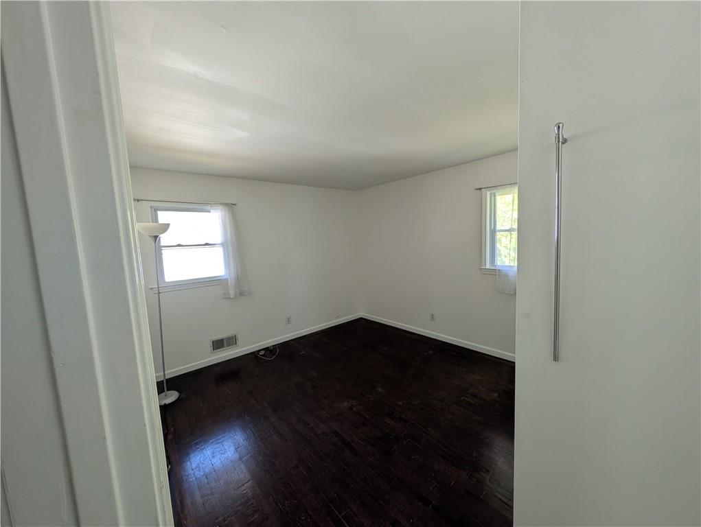 4328 Rockbridge Road Southwest Stone Mountain, GA 30083 - Photo 8 of 16 an empty room with wooden floor and windows