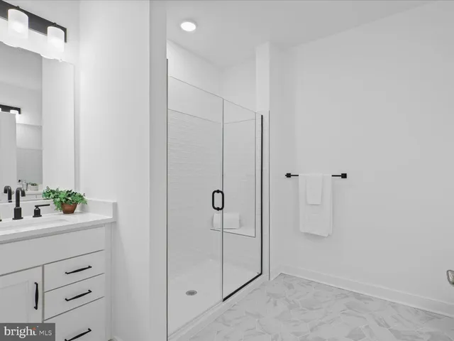 a bathroom with a shower sink vanity and mirror