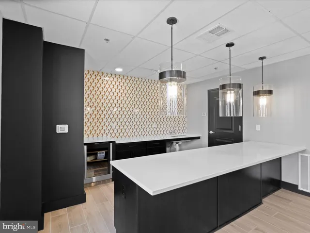 a view of an empty room with a fireplace and chandelier