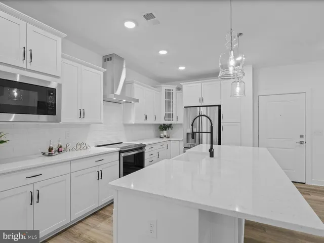 a kitchen with kitchen island a sink stainless steel appliances and cabinets